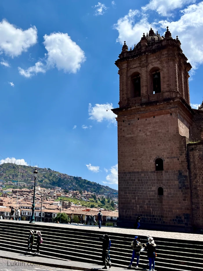 A small town with an old building and mountains in the background.