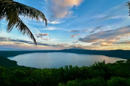 Sunset view of a lake with a volcano in the background.