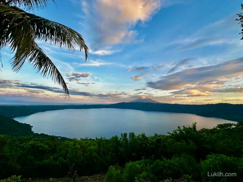 Sunset view of a lake with a volcano in the background.