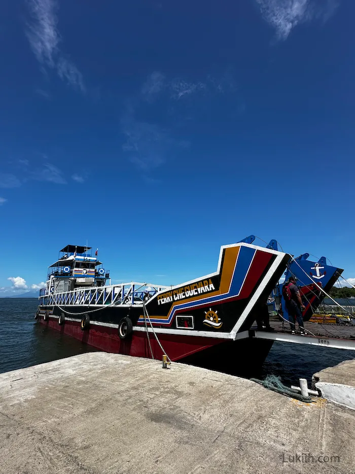 A big red ferry docked at a pier.