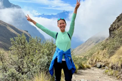 A woman on a hiking trail above the clouds.