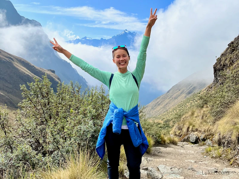 A woman on a hiking trail above the clouds.