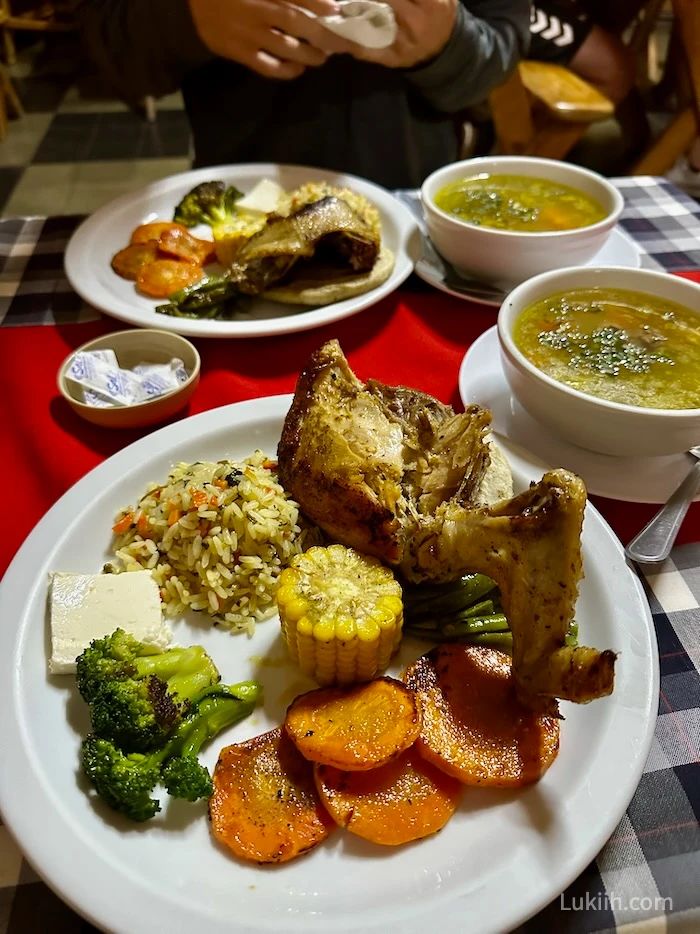 A plate with chicken, rice, corn, carrots, cheese, and broccoli.