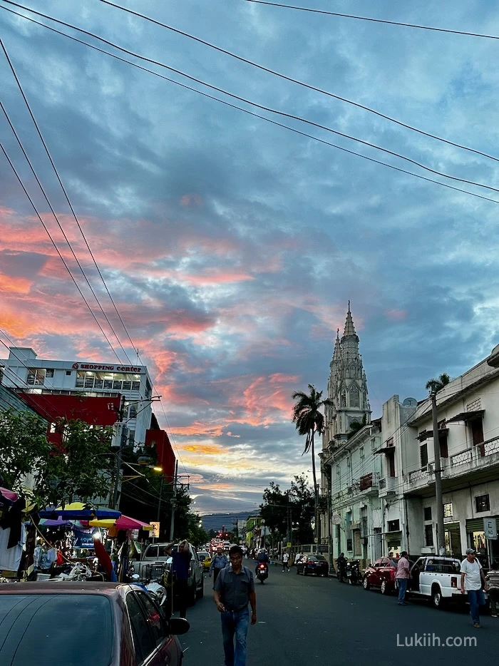 A street during sunset with a church.