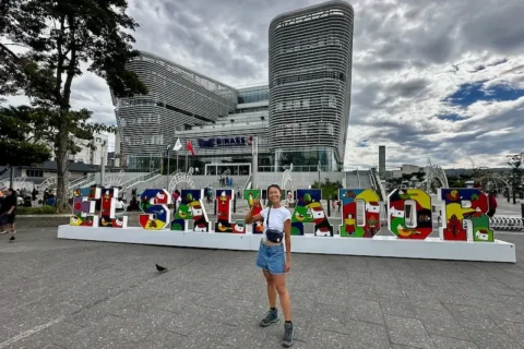 A woman standing in front of a sign that says El Salvador.