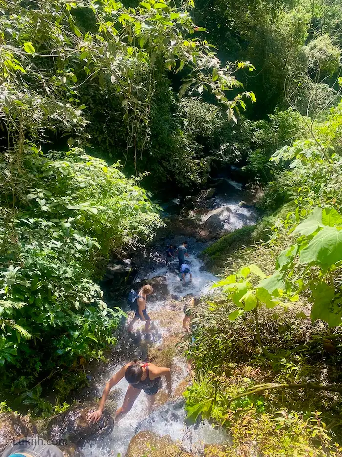 Several people climbing up a waterfall.