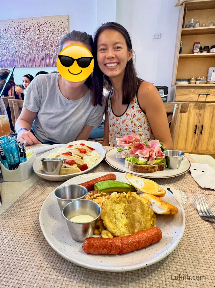 A plate with sausages, arepas, avocado, eggs, and sauce.