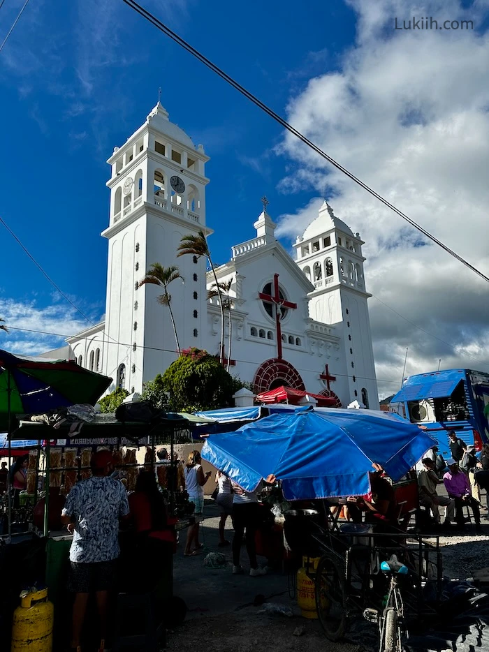 A white church with food vendors at its base.