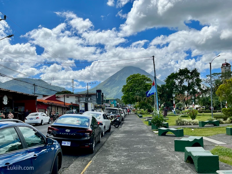 A tropical town with a towering volcano.