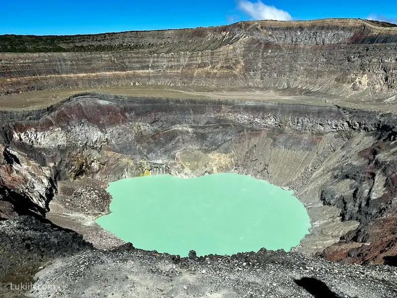 A crater lake with vibrant emerald turquoise color.