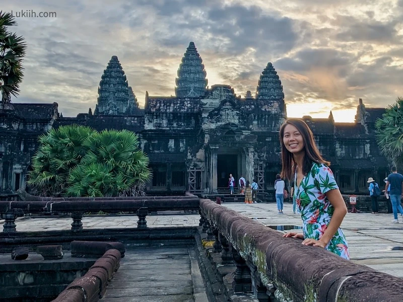 A woman with an ancient building with three beaks in the background.