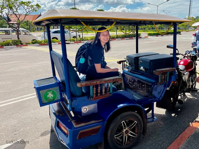 A woman riding a tuk-tuk.