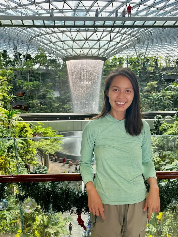 A woman standing in front of a modern and unique waterfall.