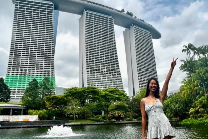 A woman standing next to a modern building.