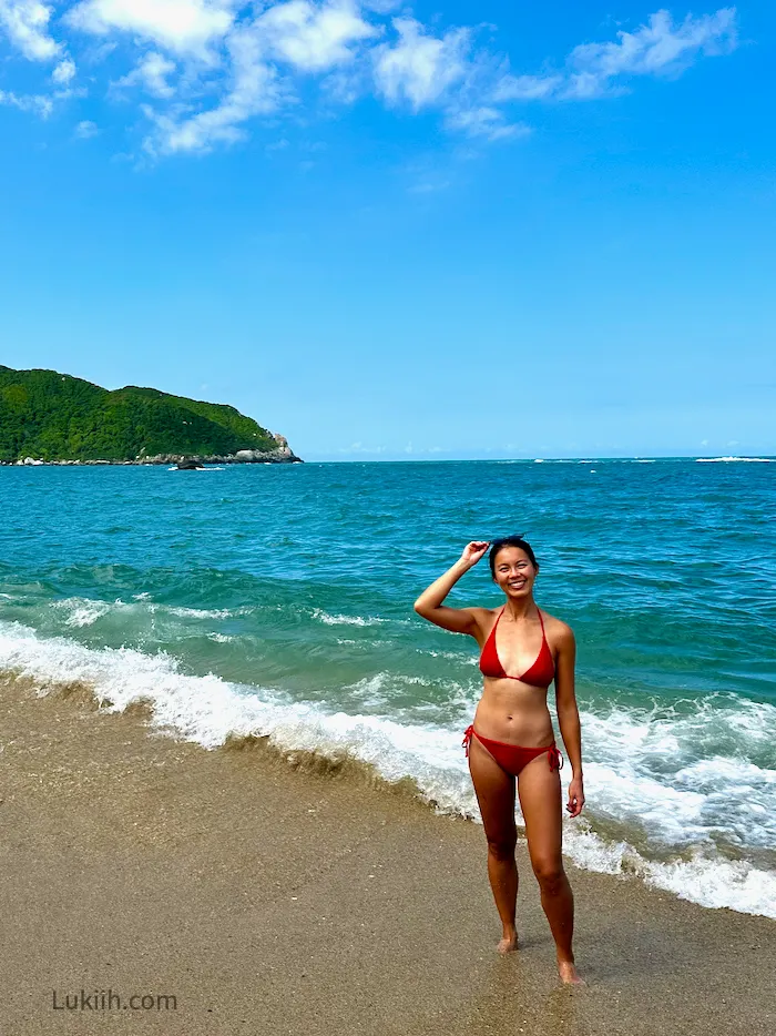 A woman on a beach with soft sand.