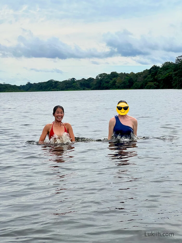 Two people swimming in an empty lake.