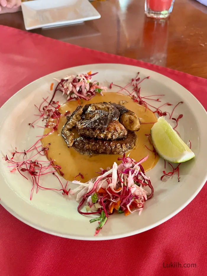 A dish with grilled octopus served with flowers.