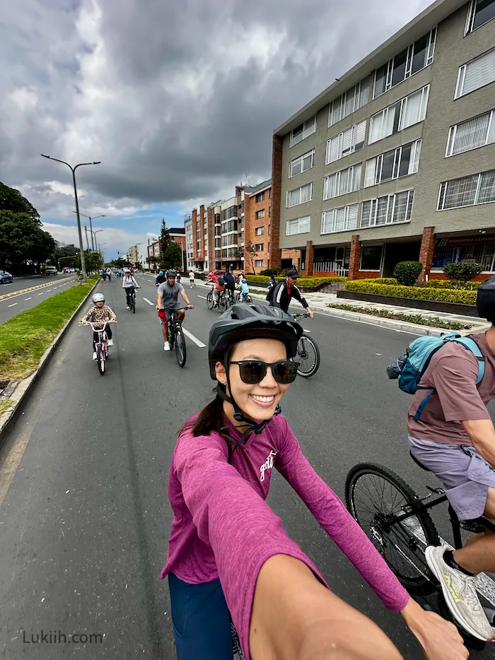 A woman biking through a street free of cars.