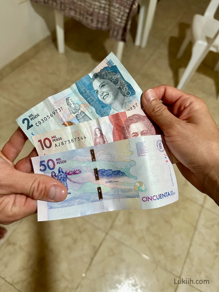 Three colorful bills that says "pesos" on them.