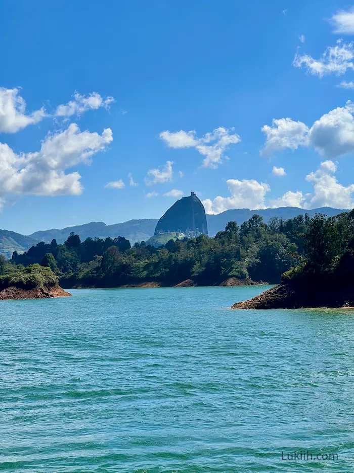 Photo taken from a boat looking at an imposing rock.