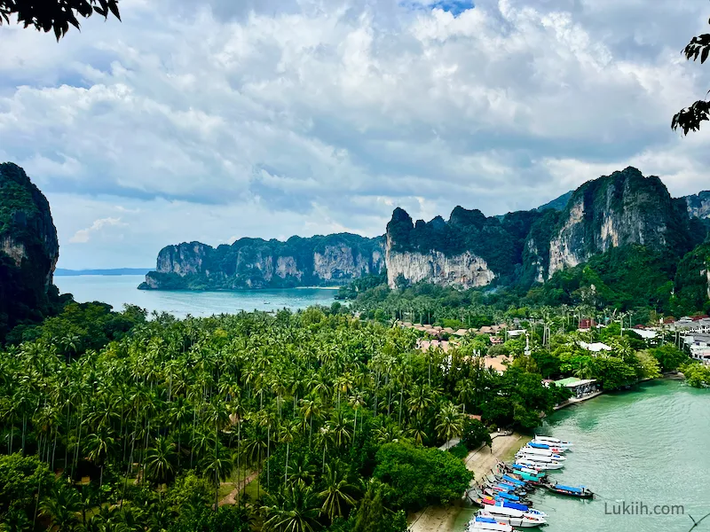 View of a lush forest with limestone cliffs and the ocean surrounding it.