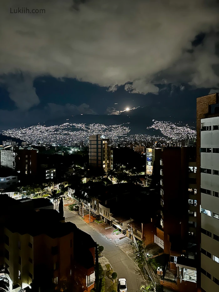 A high-up view of a city at night, with many lights up on a mountain.