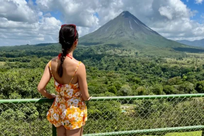 A woman staring out at a volcano.