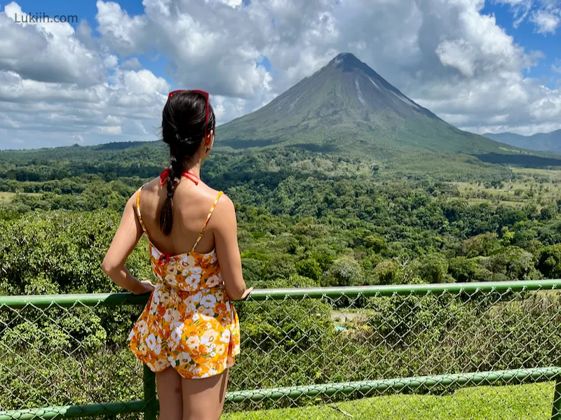 A woman staring out at a volcano.