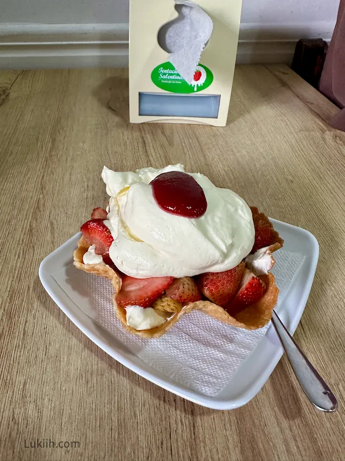 A waffle holding strawberries and whipped cream.