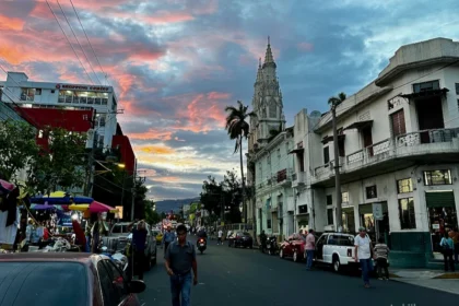 A street with an old cathedral and bustling street vendors.