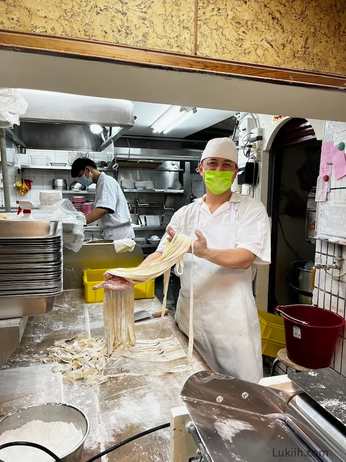 A chef holding handmade noodles.