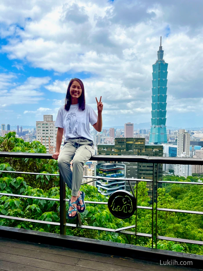 A woman in front of a tall, modern, blue building.