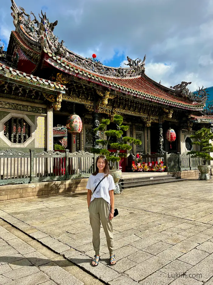 A woman standing in front of an ancient temple.