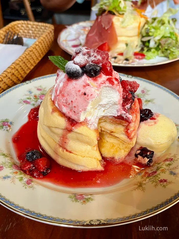 A fluffy pancake with cream and berries.