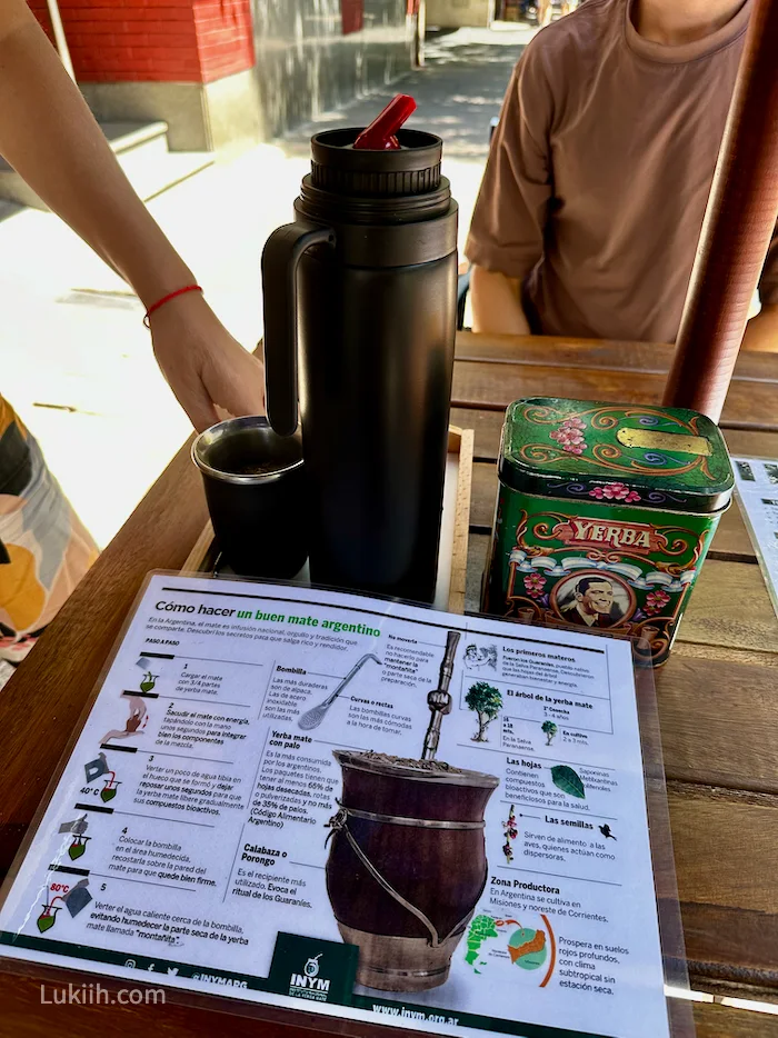 A thermos next to a wooden cup and tin of "yerba."