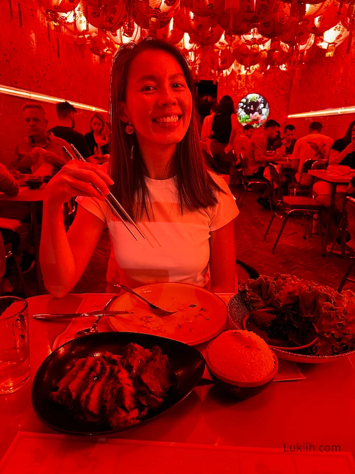 A woman eating a medium-rare steak.