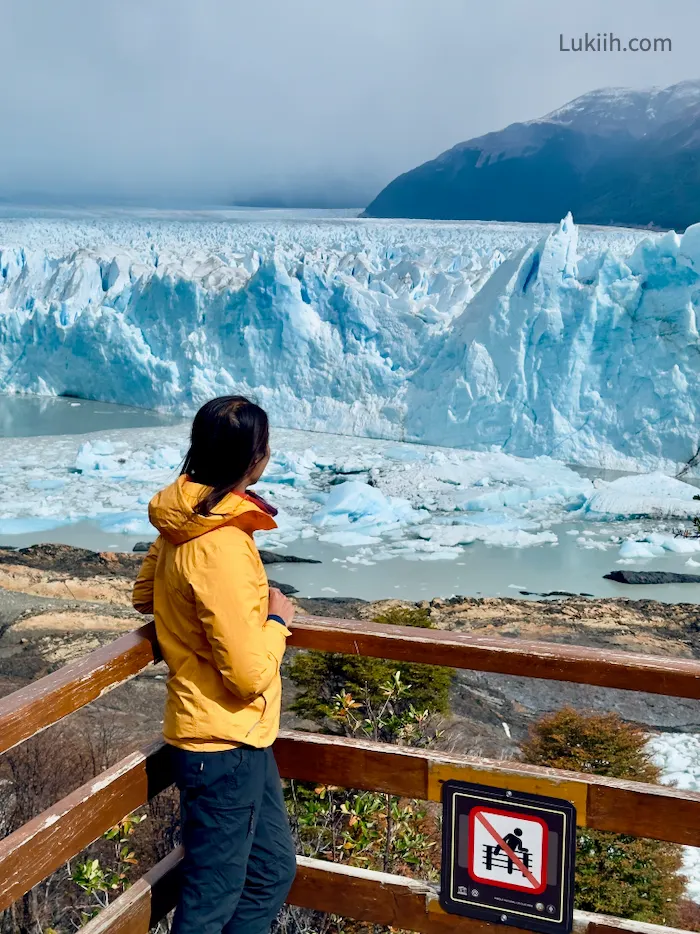 A woman looking at a massive, unique glacier.